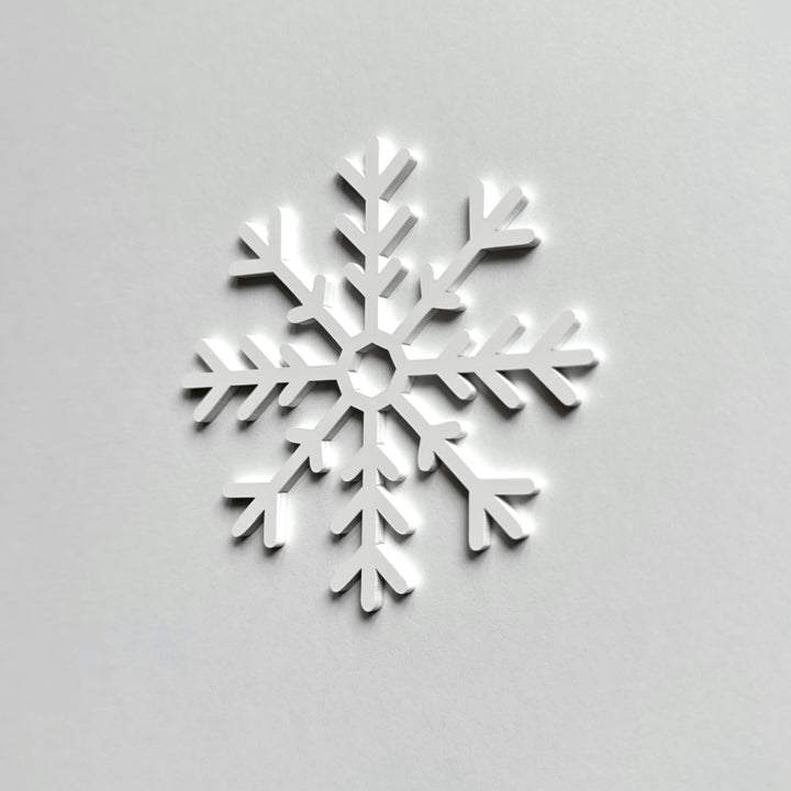 A white snowflake is centered against a plain white background. A white snowflake is centered against a plain white background.