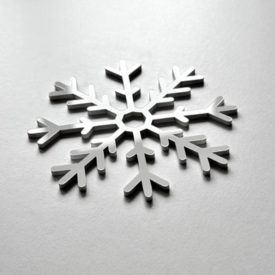 A silver snowflake-shaped object is centered on a plain white background.