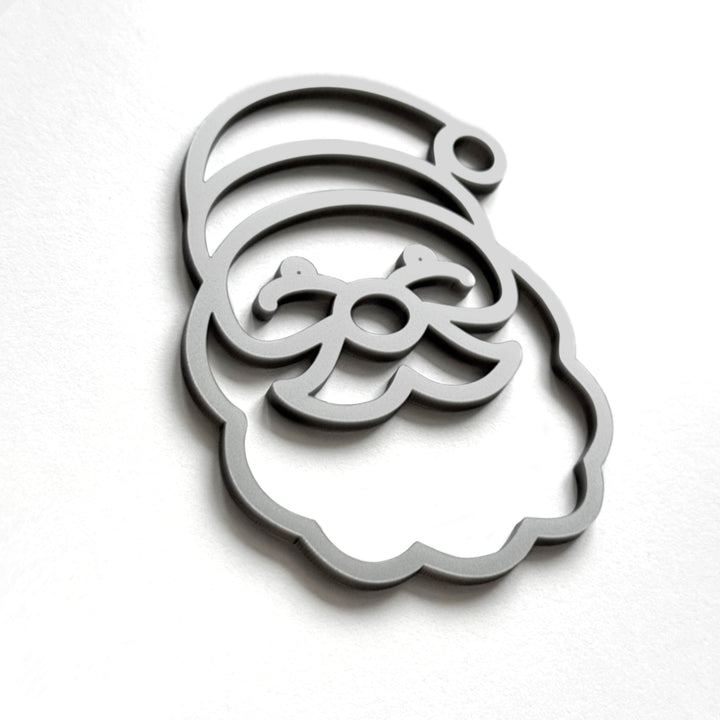 A stylized silhouette of a smiling face, resembling a cartoon or holiday-themed design, is shown against a plain white background.