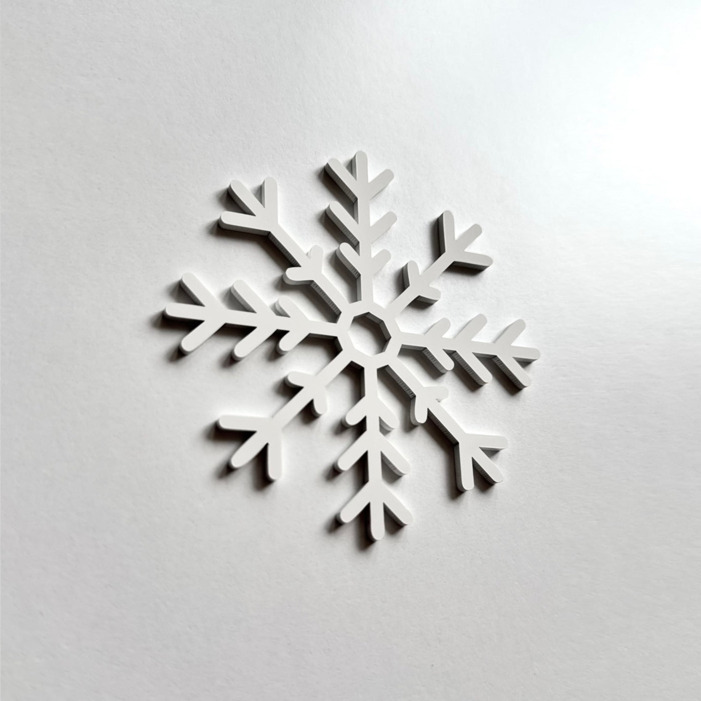 A white snowflake-shaped object is displayed against a plain white background.
