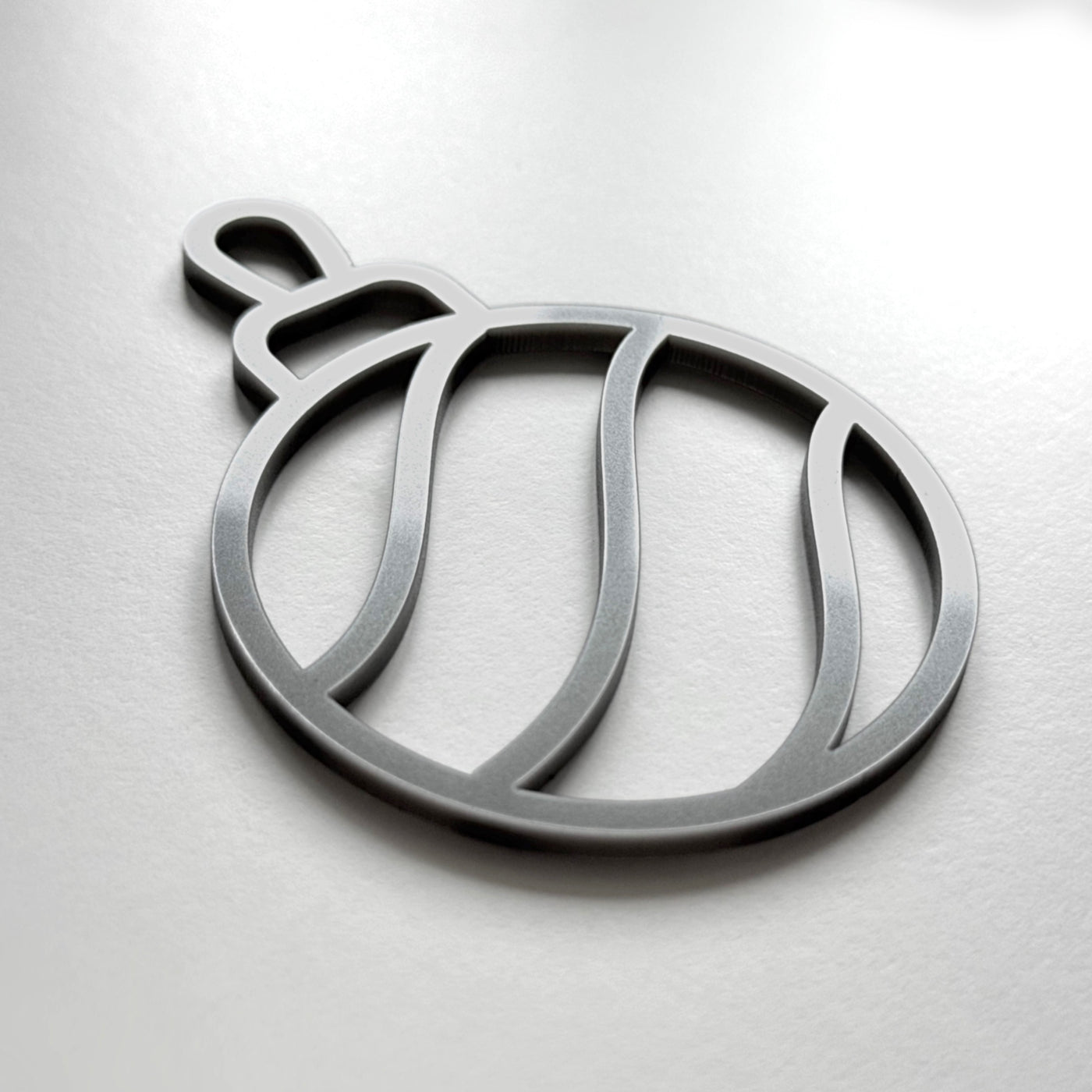 A silver ornament in the shape of a ball with a curved design.