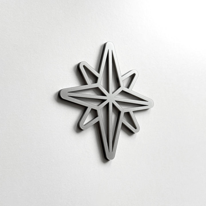 A silver star-shaped object is mounted on a white wall.