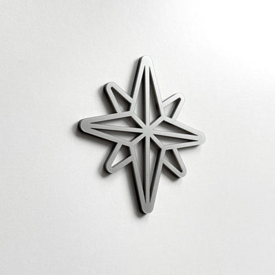 A silver star-shaped object is mounted on a white wall.