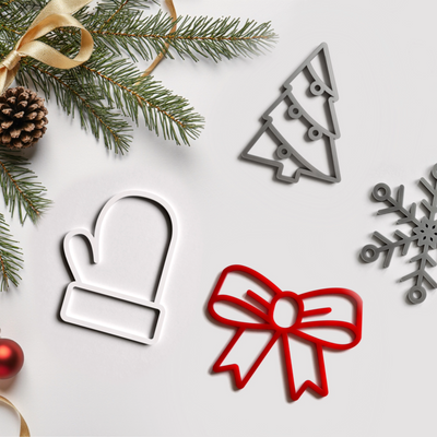 a festive arrangement of Christmas decorations, including a pine branch, a Christmas tree, a white mitten, a red bow, and a snowflake.
