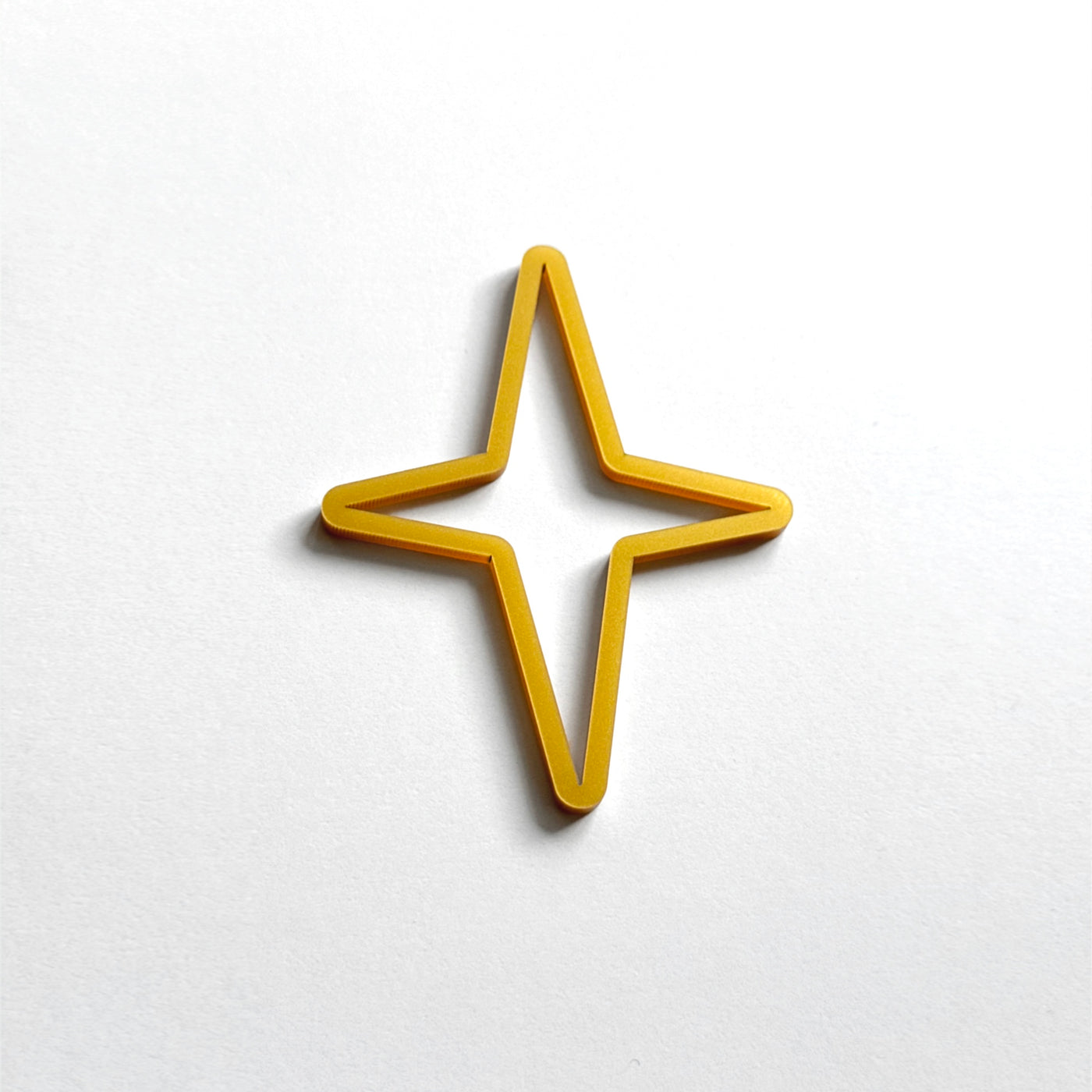 A single, gold-colored star-shaped object is centered against a plain white background.
