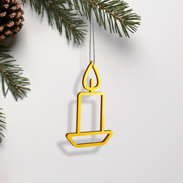 A yellow candle-shaped ornament hangs from a branch, with pine needles and a pine cone visible in the background.