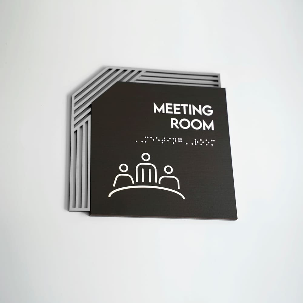 a black and white photo of a meeting room sign