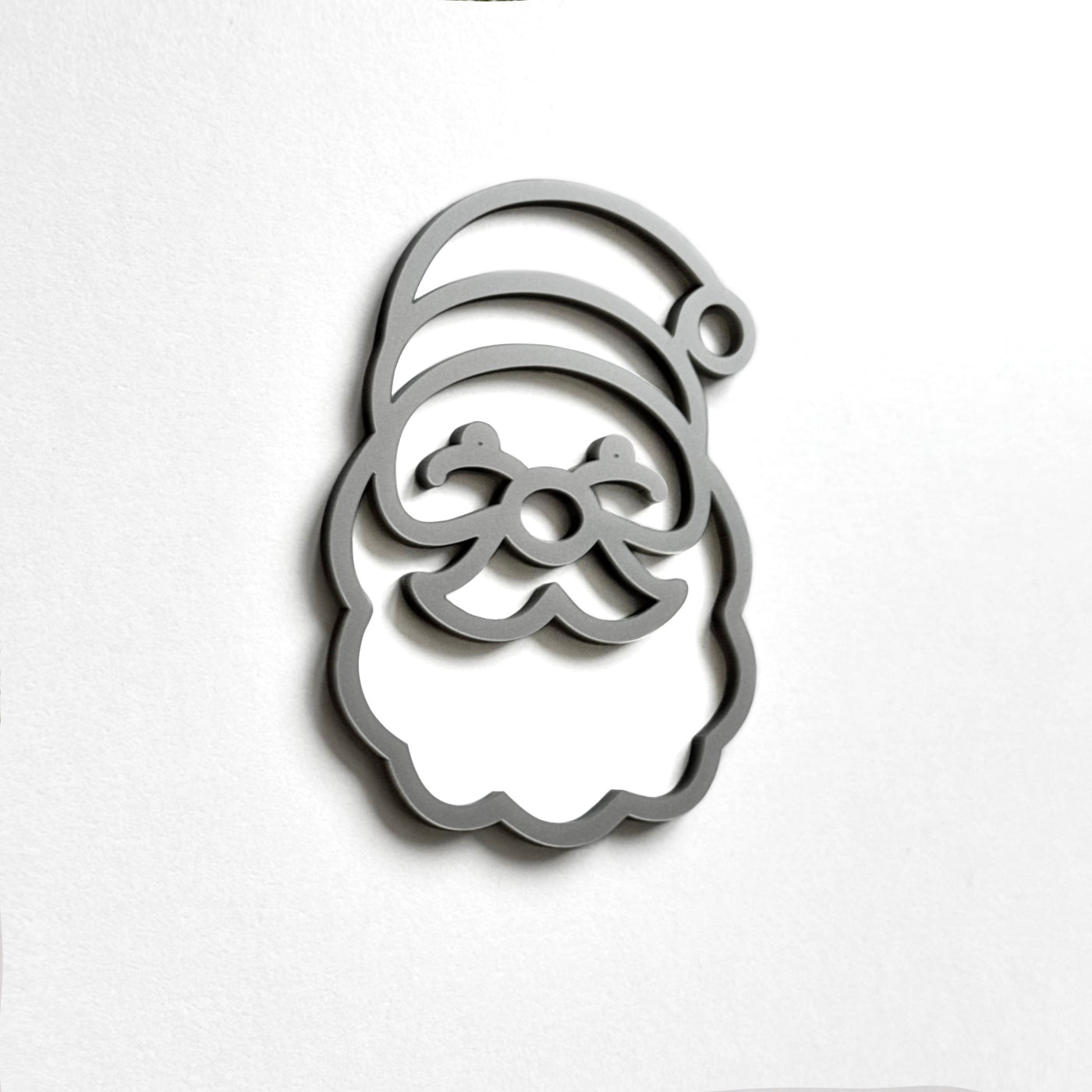 A stylized silhouette of a smiling face, resembling a cartoon or holiday-themed character, is displayed against a plain white background.