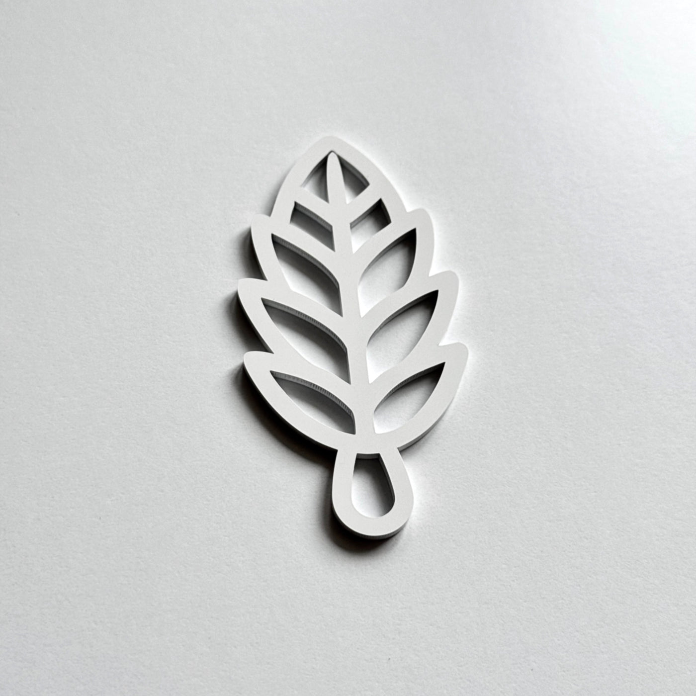 A white leaf-shaped object with a simple, minimalist design.