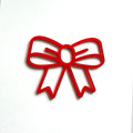 A red bow-shaped cutout is displayed against a white background. - Photo #1
