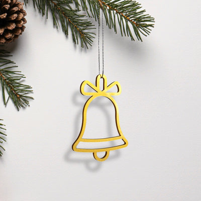 A golden bell ornament hangs from a branch of a pine tree, creating a festive and holiday-themed scene.