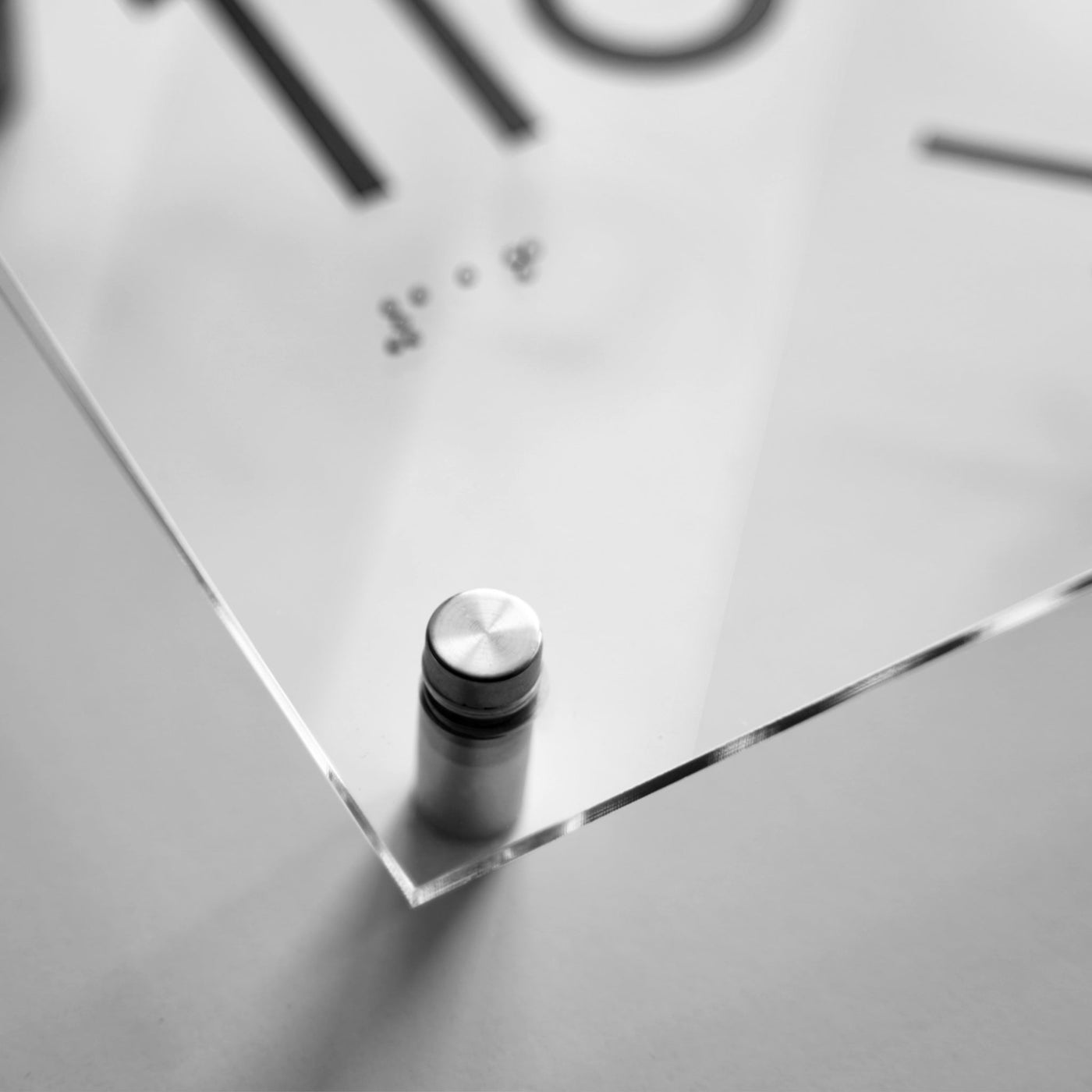 a close up of a glass table with a clock in the background