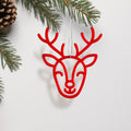 A red deer head ornament with antlers is hanging from a string, surrounded by pine branches and pine cones. - Photo #2