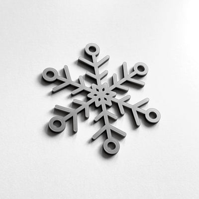 A silver snowflake ornament is displayed against a white background.