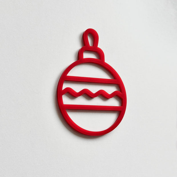 A red Christmas ornament-like object with a wavy pattern on a white background.