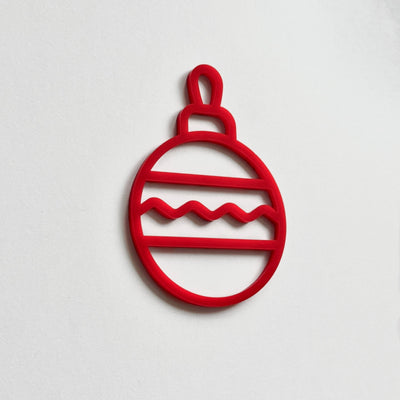 A red Christmas ornament-like object with a wavy pattern on a white background.