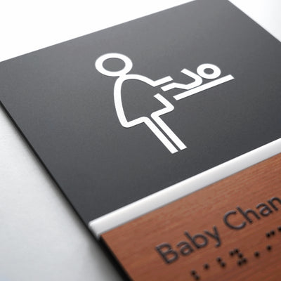 a baby changing sign on a wooden plaque