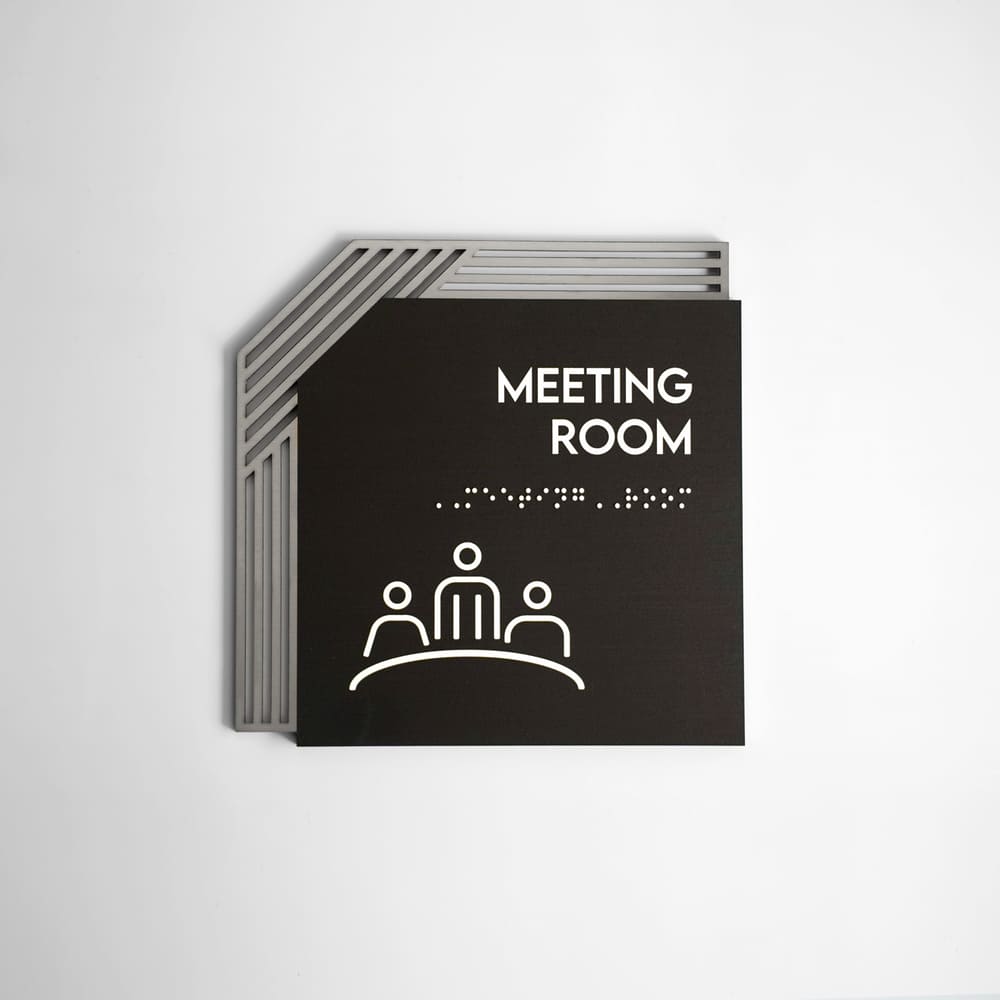 a black and white photo of a meeting room sign