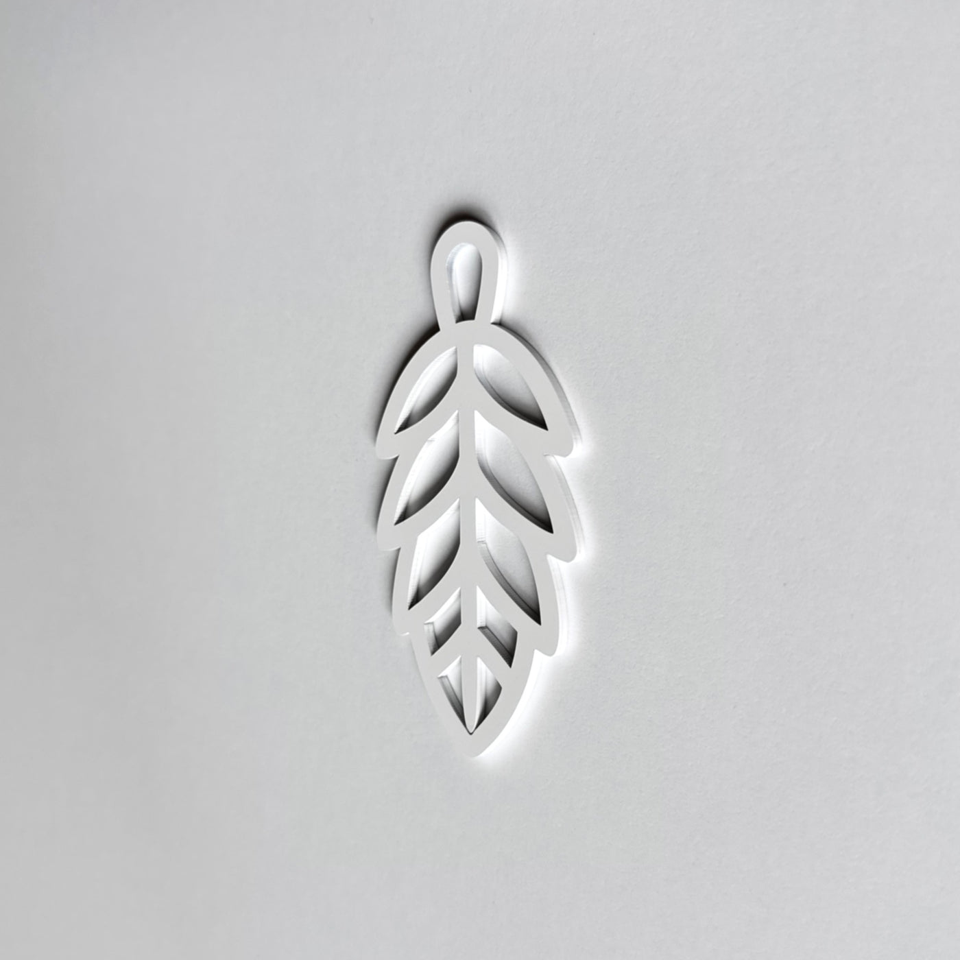 A white leaf-shaped object is centered against a plain white background.