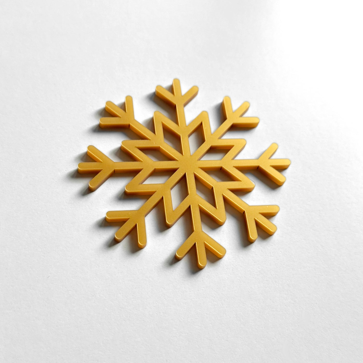 A golden snowflake-shaped object is centered on a white background.