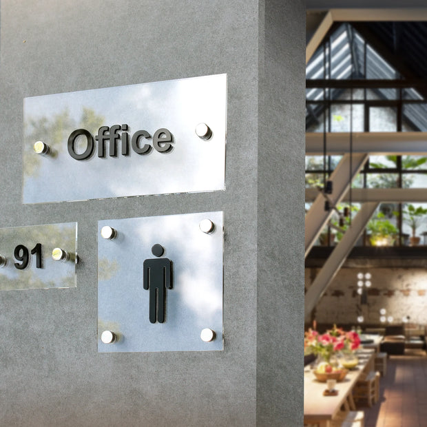 Office door sign made of acrylic and stainless steel mounted on a concrete wall in a modern interior