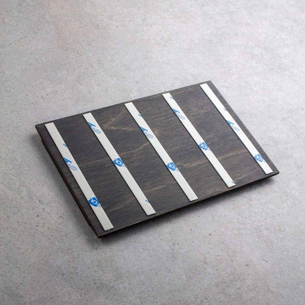 Back view of interior sign showing wooden base with adhesive mounting strips for wall installation